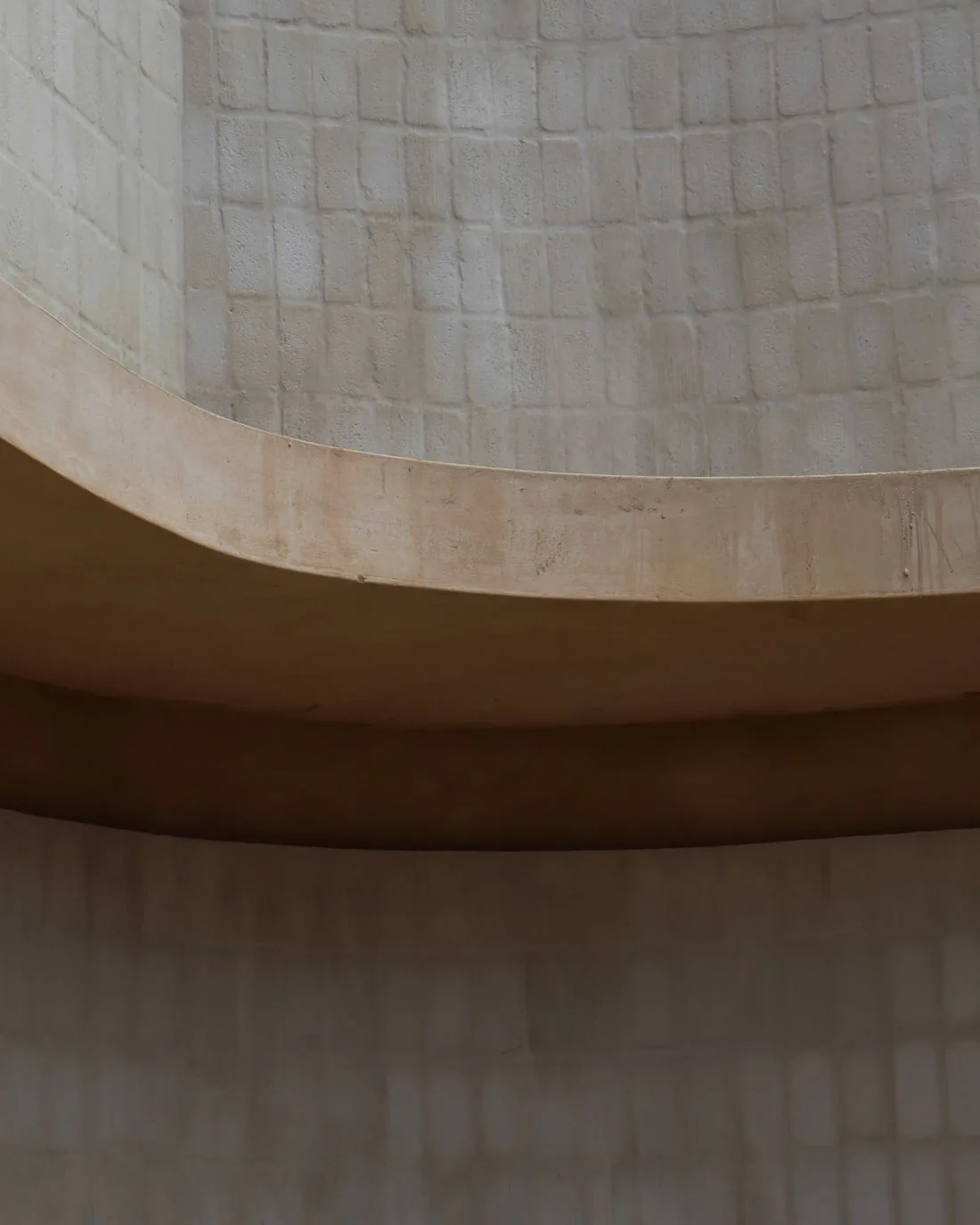 A curved plaster archway in warm neutral stone